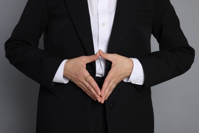 Photo of Woman in suit on grey background, closeup
