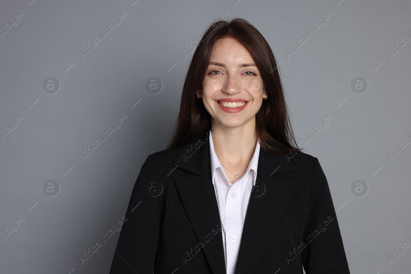 Photo of Happy woman in suit on grey background, space for text