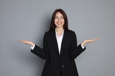 Photo of Happy woman in suit on grey background