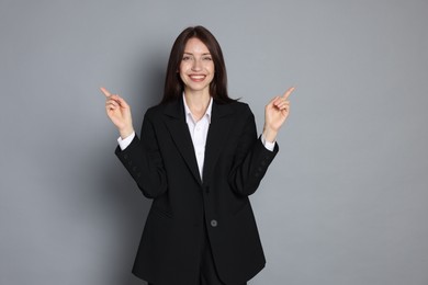 Photo of Happy woman in suit on grey background