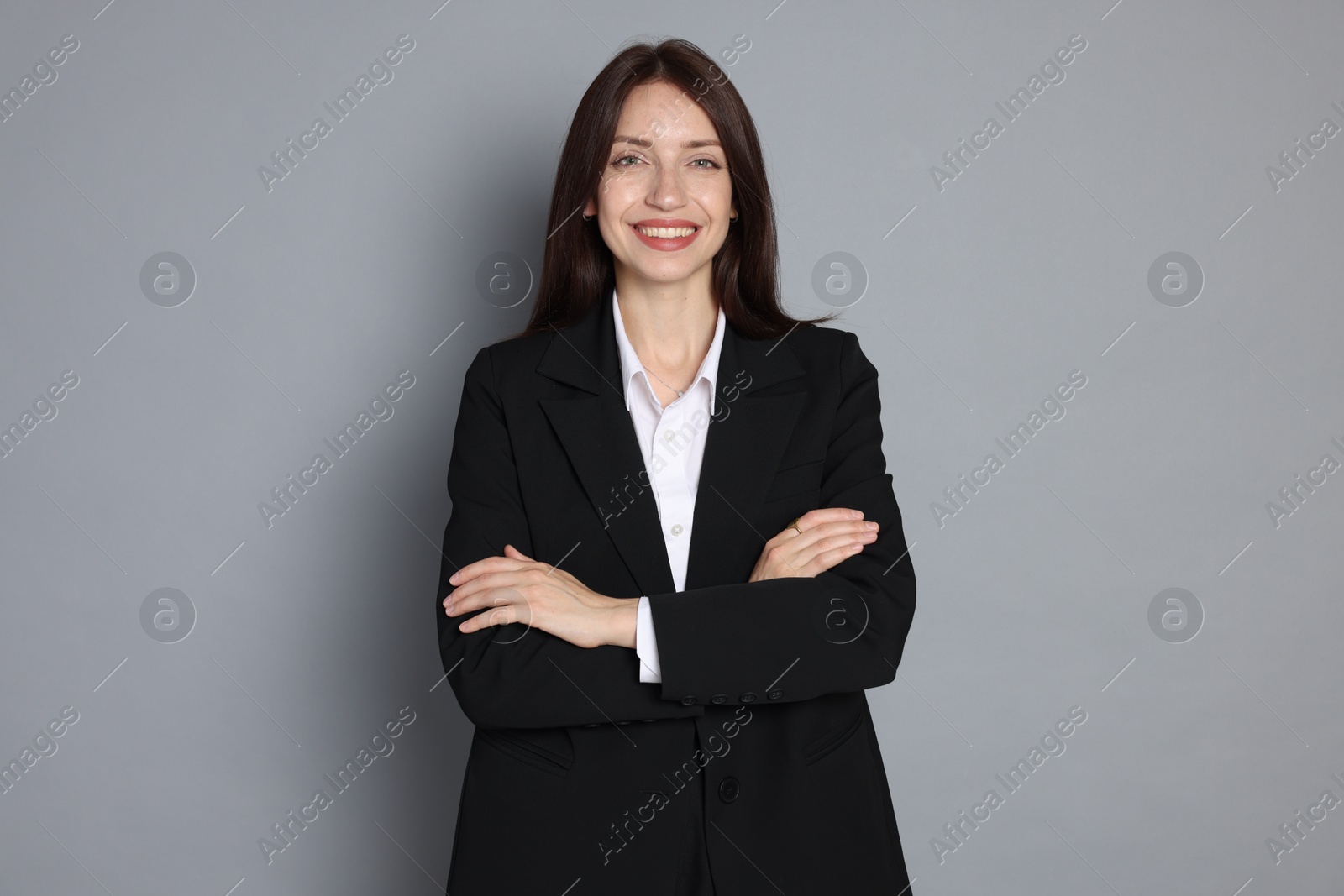 Photo of Happy woman in suit on grey background