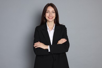 Photo of Happy woman in suit on grey background