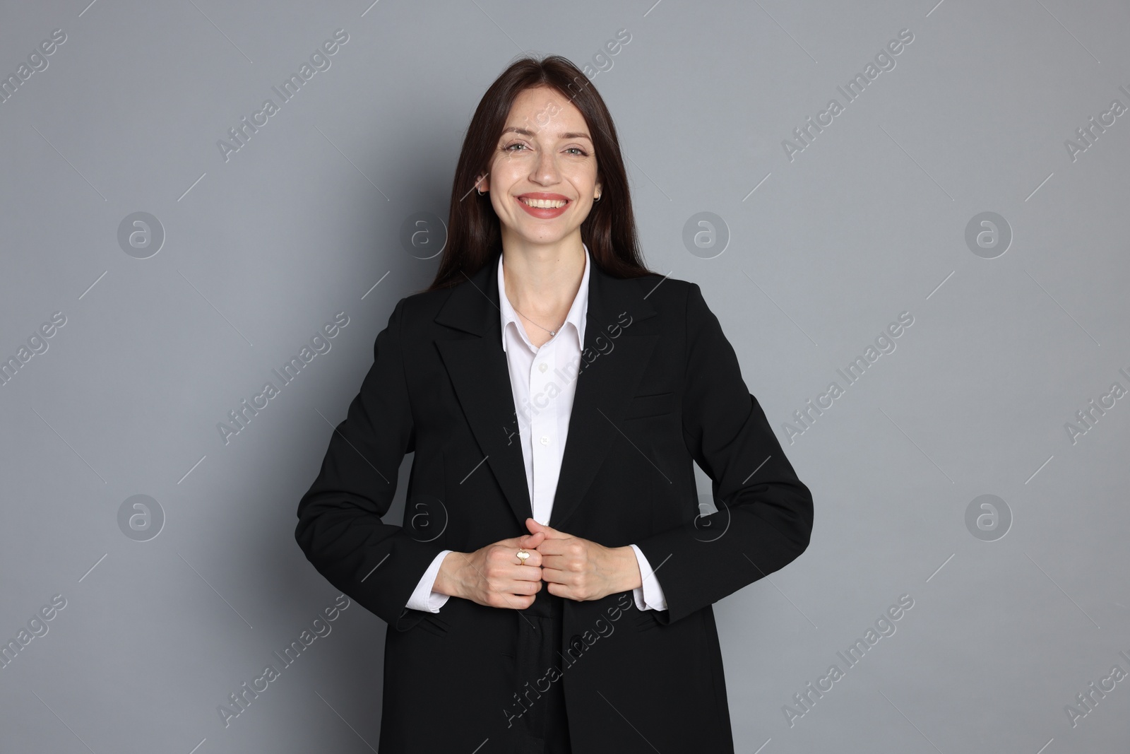 Photo of Happy woman in suit on grey background