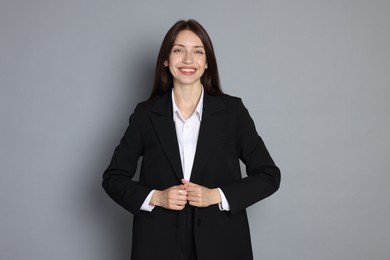 Photo of Happy woman in suit on grey background