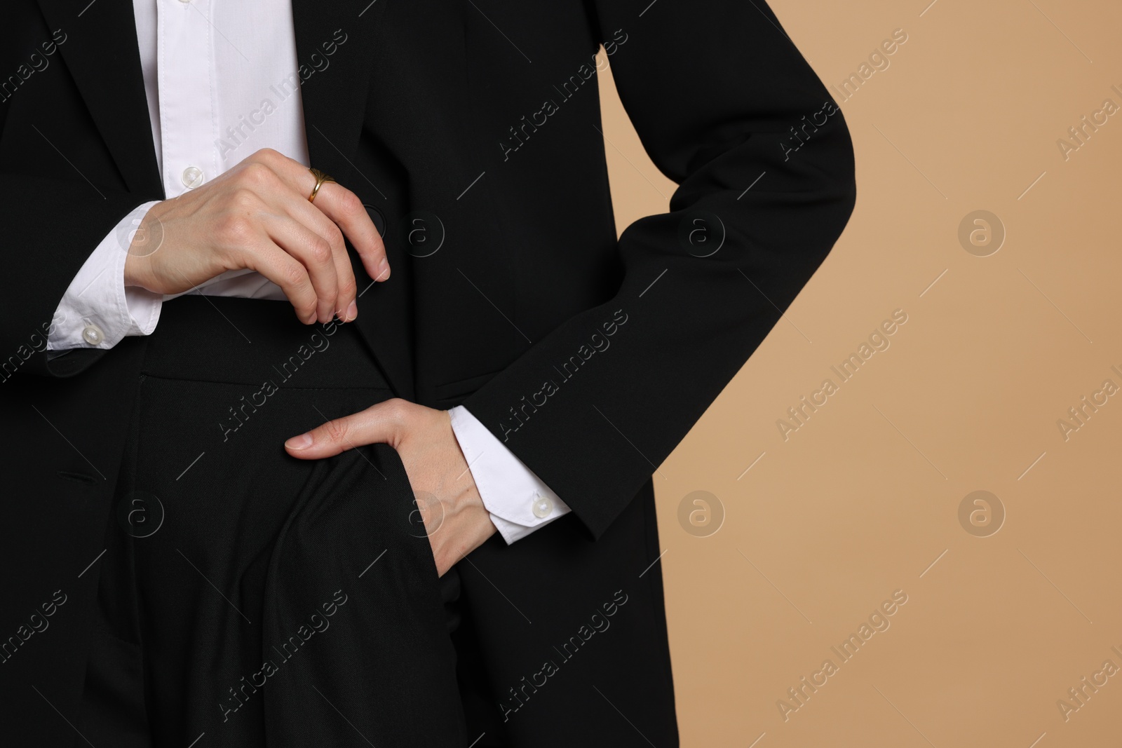 Woman in suit on beige background, closeup. Space for text Photo of Woman in suit on beige background, closeup. Space for text