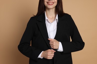 Photo of Woman in suit on beige background, closeup