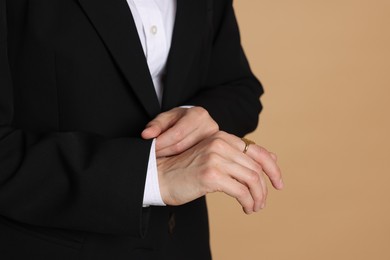 Photo of Woman in suit on beige background, closeup. Space for text