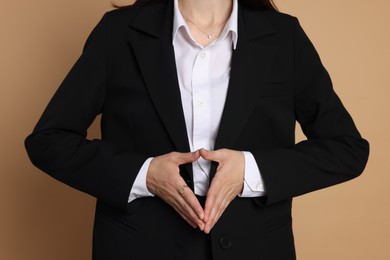 Photo of Woman in suit on beige background, closeup