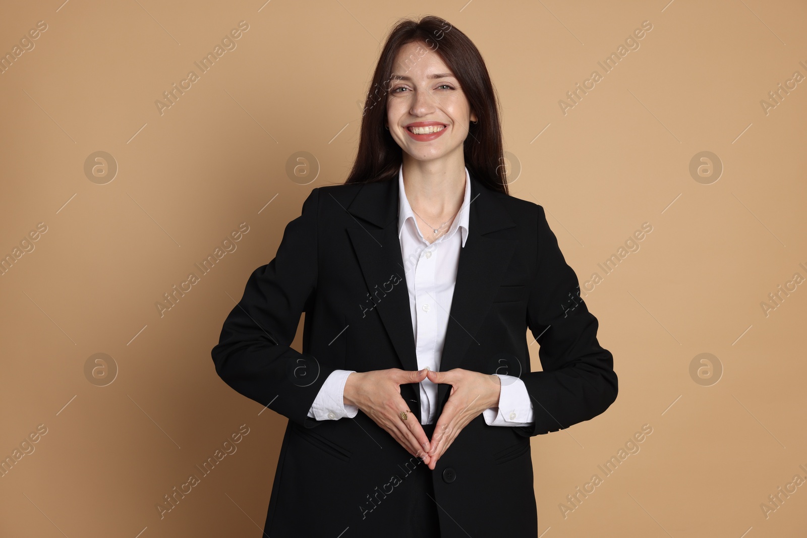 Photo of Happy woman in suit on beige background