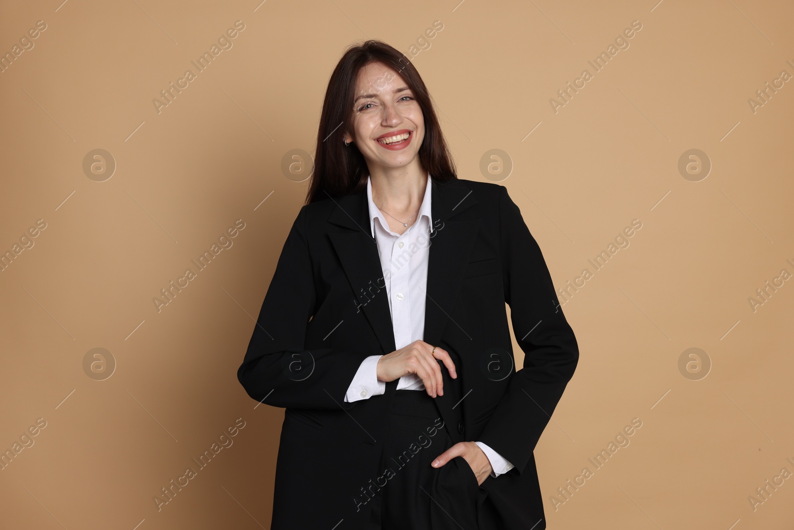 Photo of Happy woman in suit on beige background