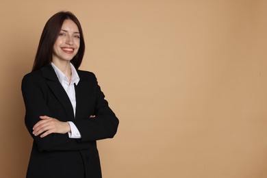 Photo of Happy woman in suit on beige background, space for text