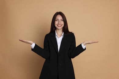 Photo of Happy woman in suit on beige background