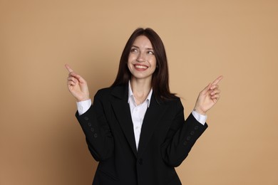 Photo of Happy woman in suit on beige background