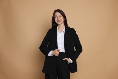 Photo of Happy woman in suit on beige background