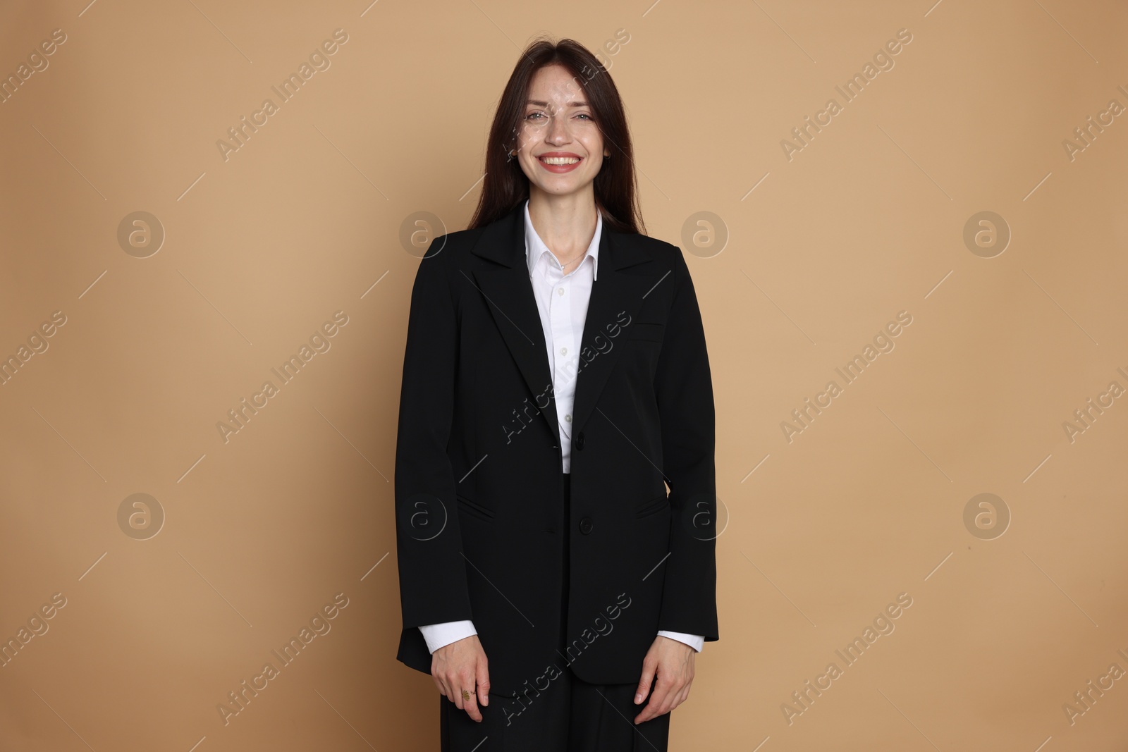 Photo of Happy woman in suit on beige background