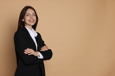 Photo of Happy woman in suit on beige background, space for text