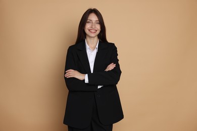 Photo of Happy woman in suit on beige background