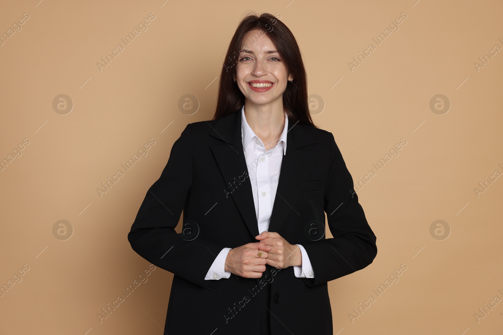 Photo of Happy woman in suit on beige background