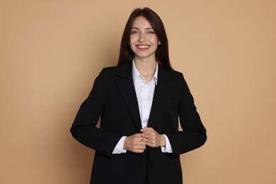 Photo of Happy woman in suit on beige background
