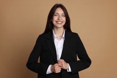 Photo of Happy woman in suit on beige background