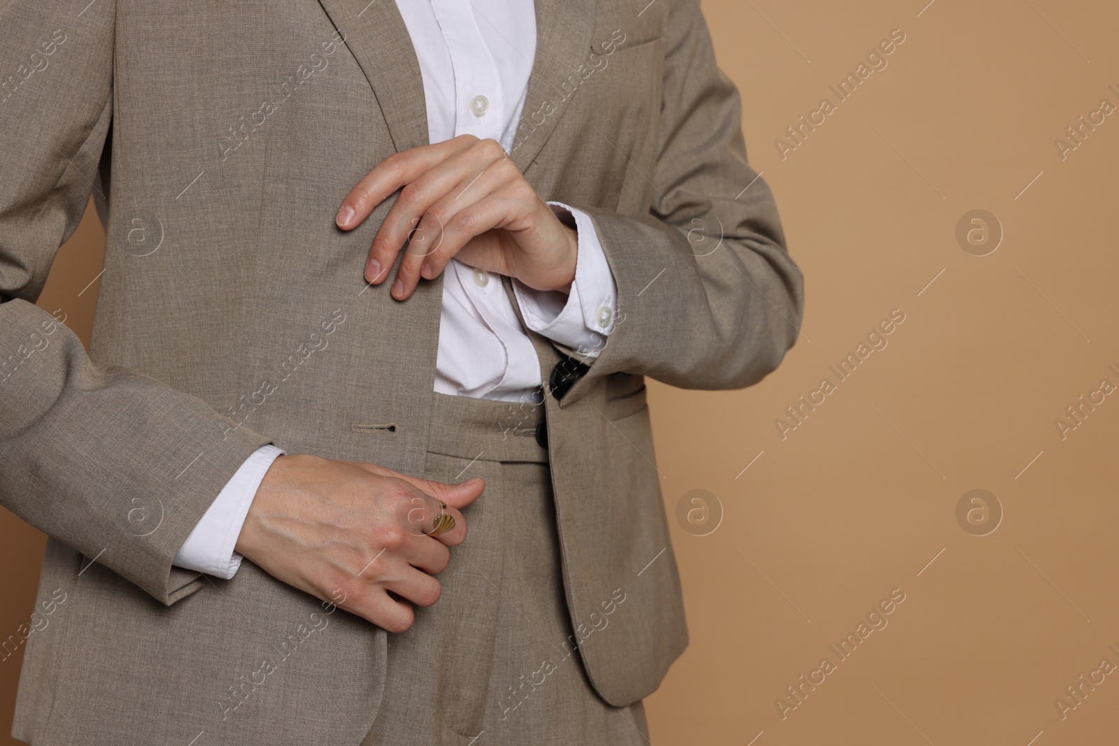 Woman in suit on beige background, closeup. Space for text Photo of Woman in suit on beige background, closeup. Space for text