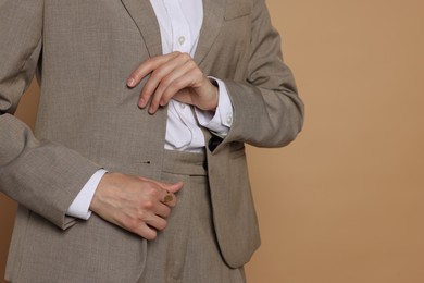 Photo of Woman in suit on beige background, closeup. Space for text