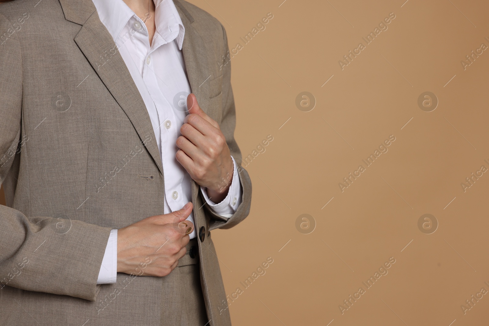Woman in suit on beige background, closeup. Space for text Photo of Woman in suit on beige background, closeup. Space for text