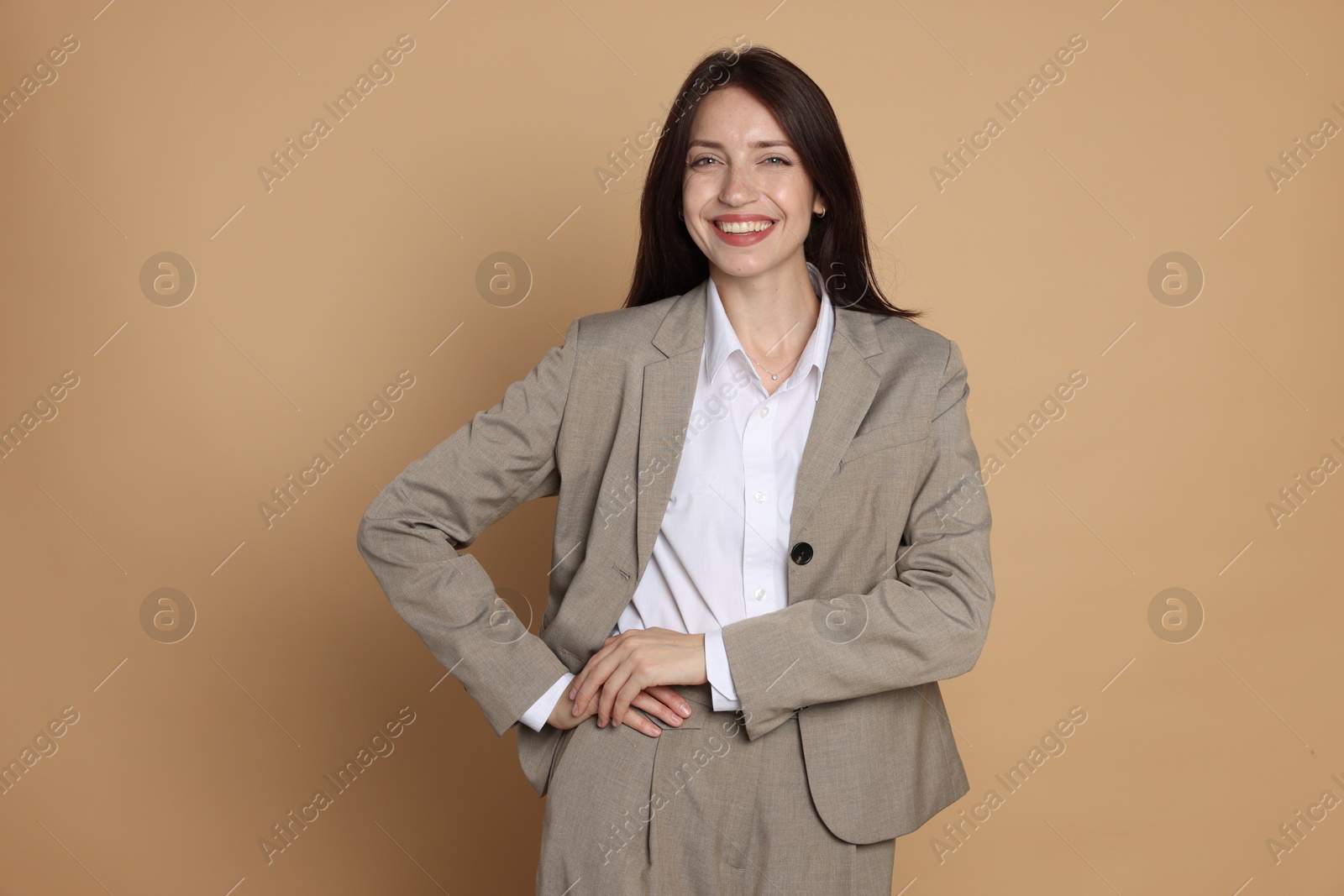 Photo of Happy woman in suit on beige background