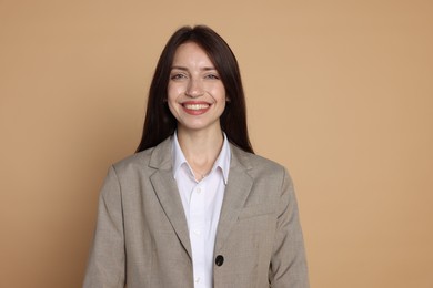 Photo of Happy woman in suit on beige background