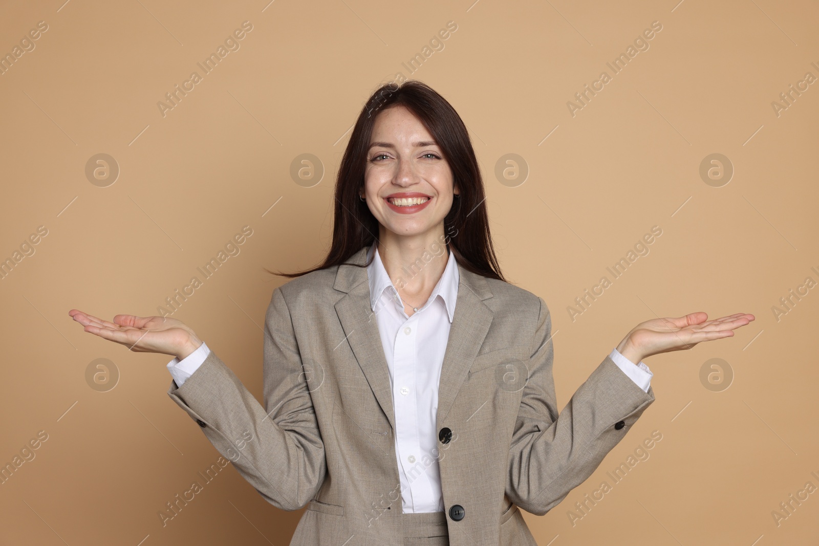 Photo of Happy woman in suit on beige background