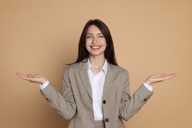 Photo of Happy woman in suit on beige background