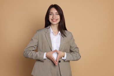 Photo of Happy woman in suit on beige background