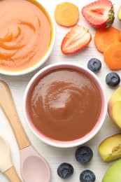 Photo of Baby food. Tasty puree in bowls and different ingredients on white wooden table, flat lay
