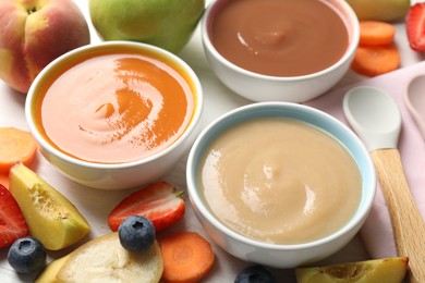 Photo of Baby food. Tasty puree in bowls and different ingredients on table, above view