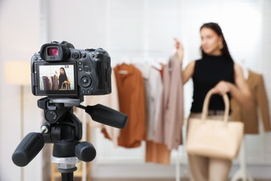 Photo of Professional stylist filming video on camera indoors, selective focus