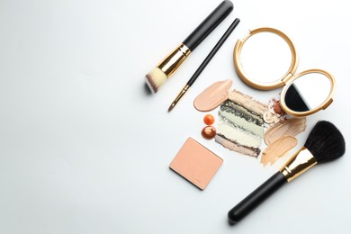 Photo of Different cosmetic products, makeup brushes and mirror on white background, flat lay. Space for text
