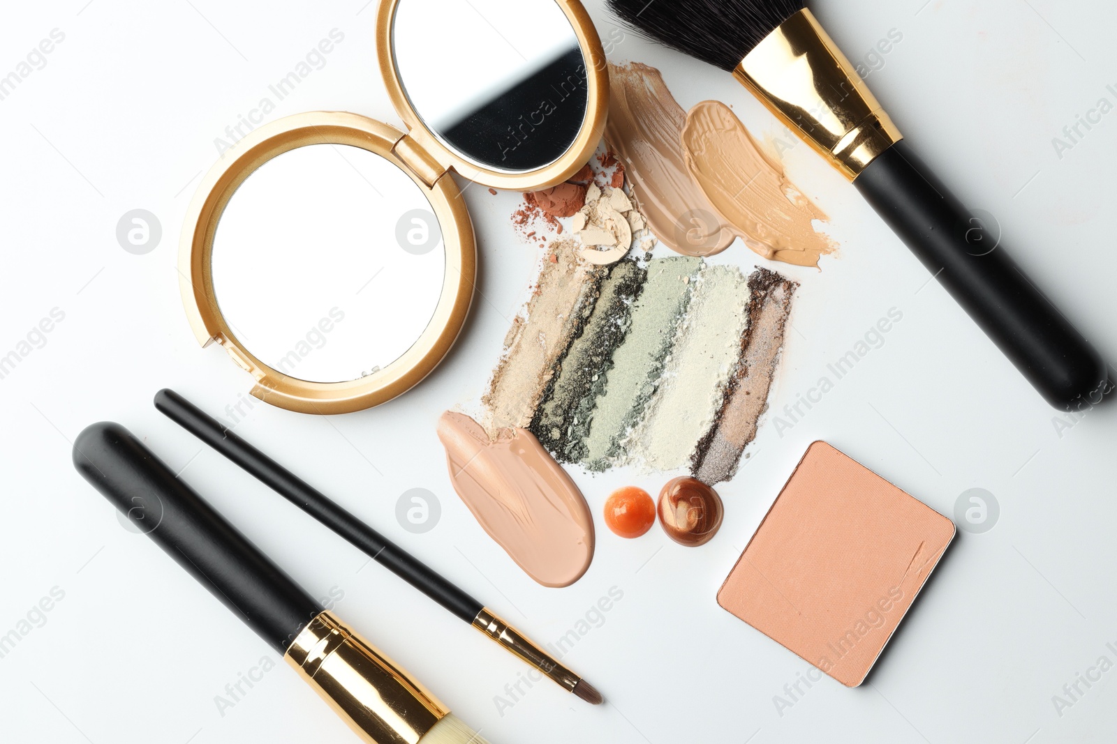 Different cosmetic products, makeup brushes and mirror on white background, flat lay Photo of Different cosmetic products, makeup brushes and mirror on white background, flat lay