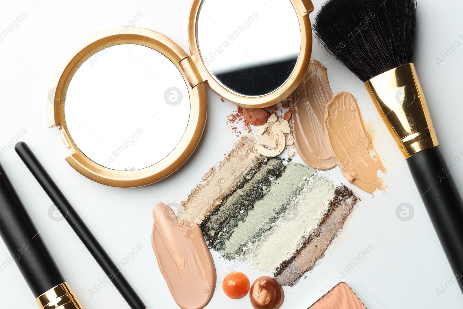 Different cosmetic products, makeup brushes and mirror on white background, flat lay Photo of Different cosmetic products, makeup brushes and mirror on white background, flat lay