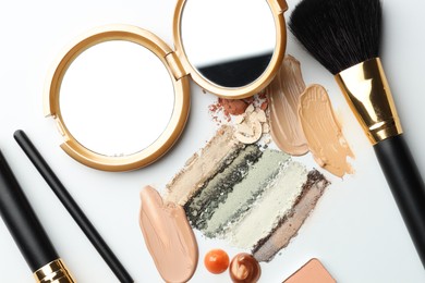 Photo of Different cosmetic products, makeup brushes and mirror on white background, flat lay
