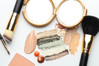 Photo of Different cosmetic products, makeup brushes and mirror on white background, flat lay