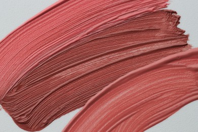 Photo of Colorful lip glosses on white background, flat lay