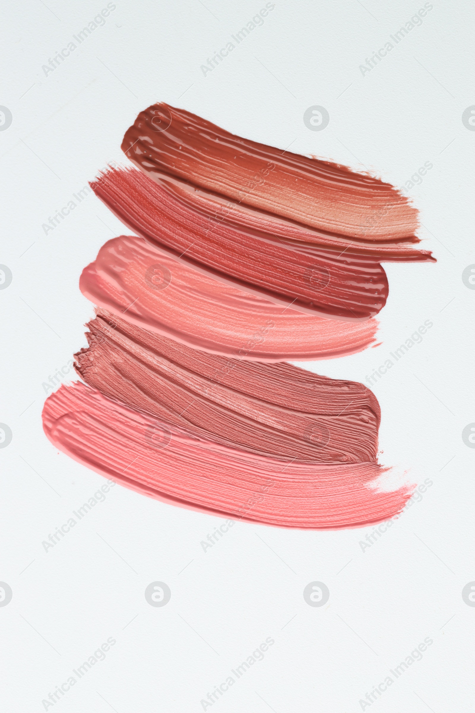 Photo of Colorful lip glosses on white background, flat lay