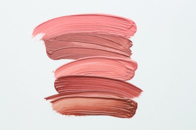 Photo of Colorful lip glosses on white background, flat lay