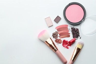 Photo of Different cosmetic products and makeup brushes on white background, flat lay. Space for text