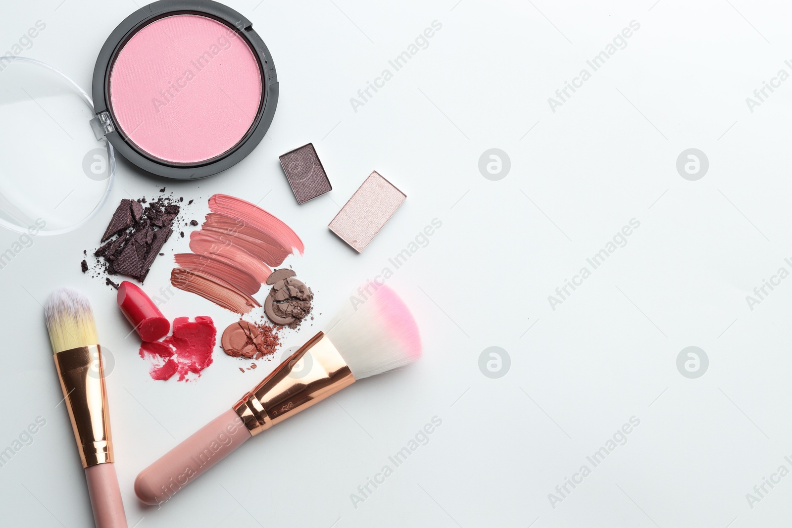 Photo of Different cosmetic products and makeup brushes on white background, flat lay. Space for text