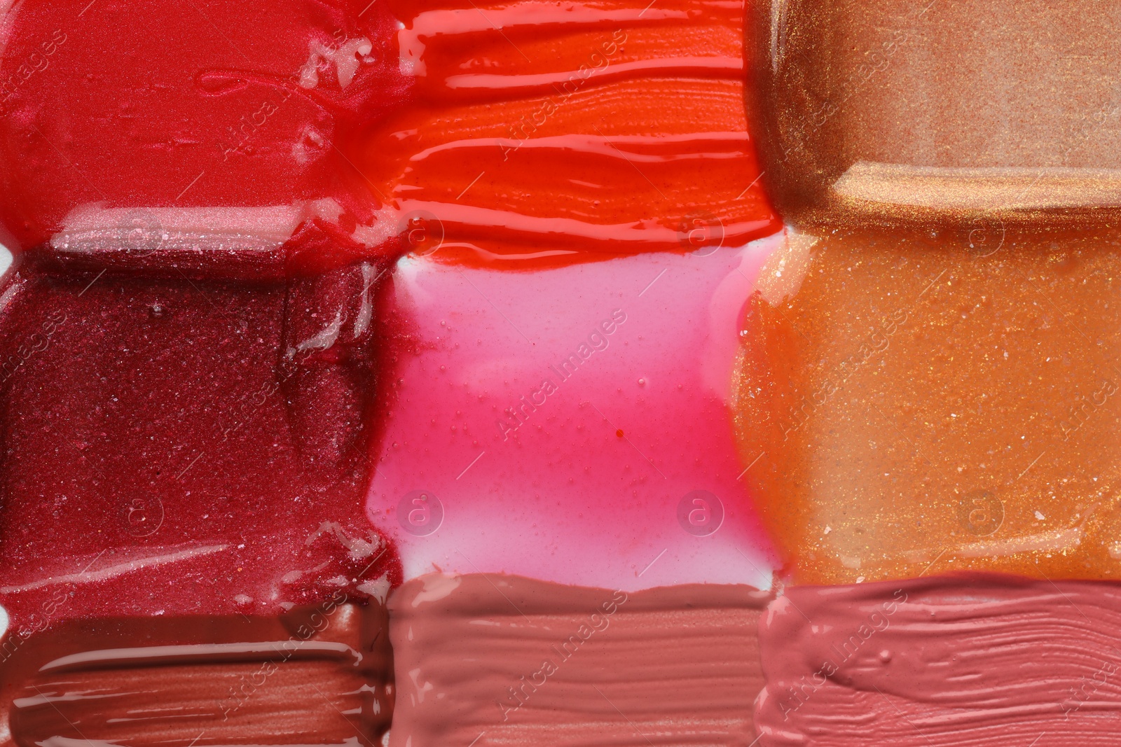 Photo of Colorful lip glosses as background, top view