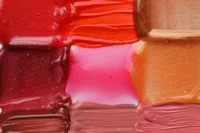 Photo of Colorful lip glosses as background, top view