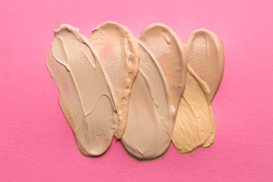 Photo of Colorful skin foundations on magenta background, flat lay