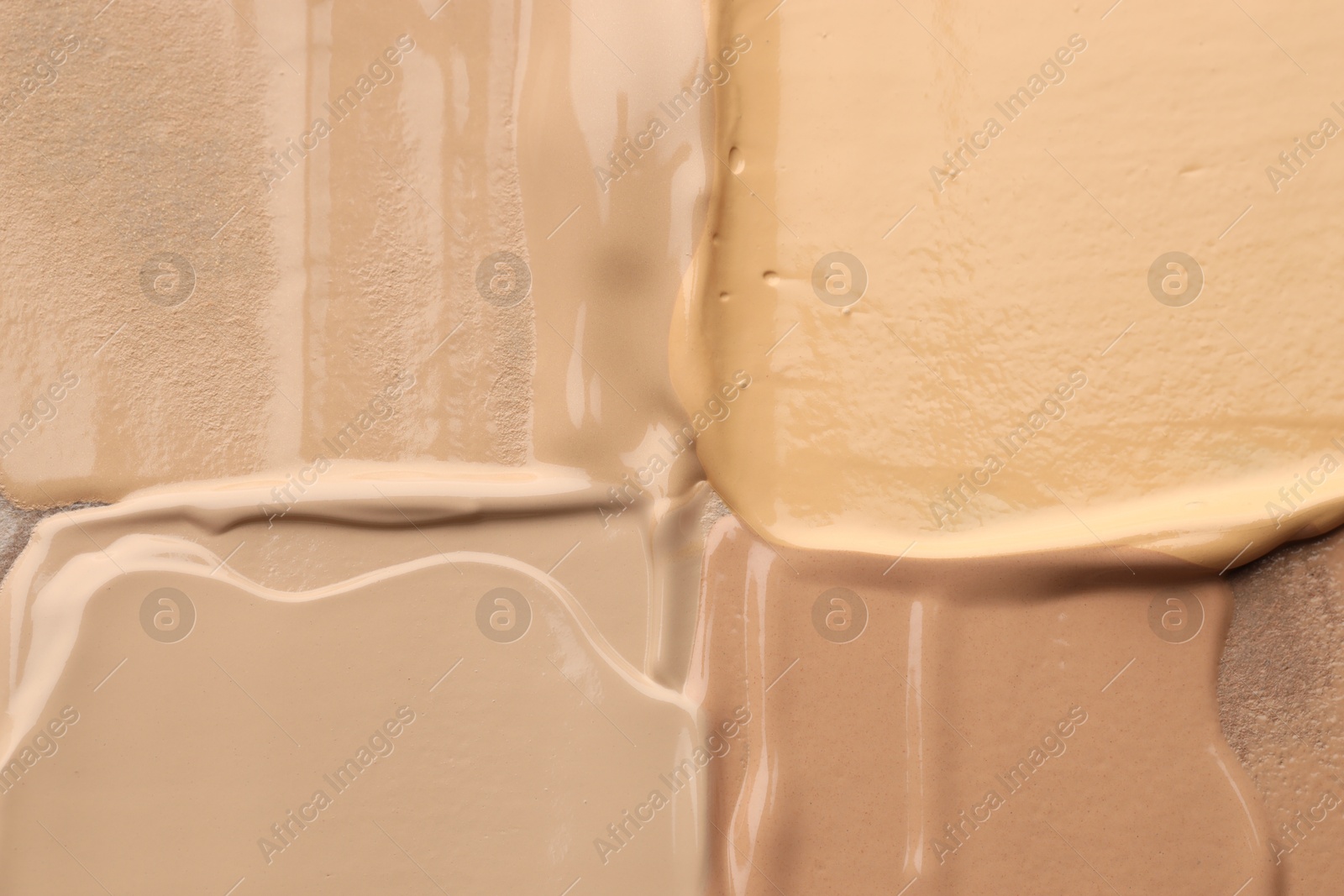 Photo of Colorful skin foundations as background, top view