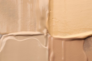 Photo of Colorful skin foundations as background, top view